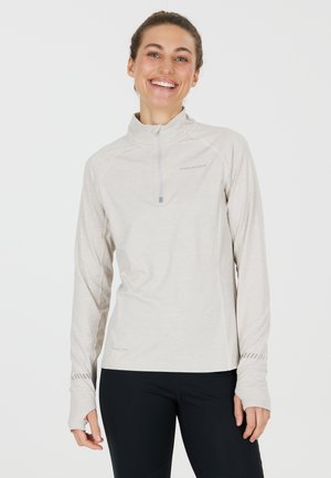 Ljusgrå långärmad topp med en fjärdedelsdragkedja, raglanärmar och tumhål. Har diskret "ENDURANCE" branding. Slät textur.