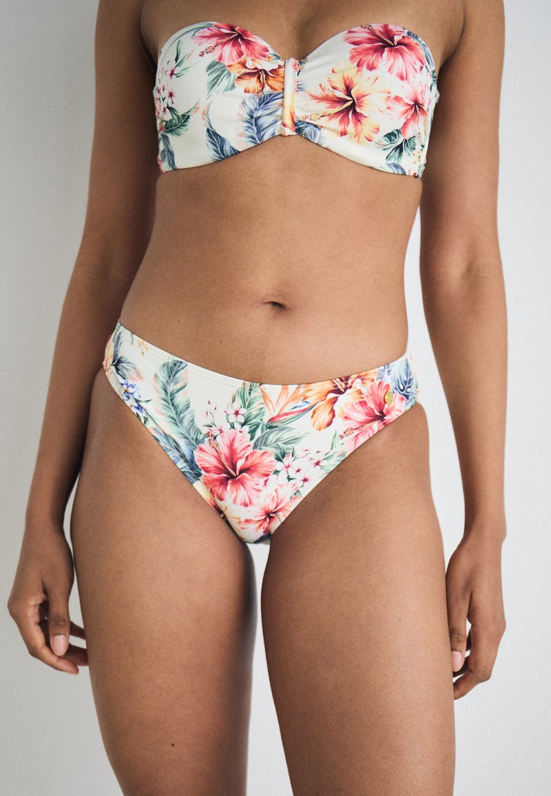 Bikini-set med blomstermønster med rosa og blå blomster på en kremfarget bakgrunn. Toppen er off-shoulder, med en midtklipsdesign.