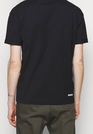 Schwarzes kurzärmliges T-Shirt mit Rundhalsausschnitt, gerade geschnitten, mit umgeschlagenen Ärmeln und kleinem Logo am unteren Saum.