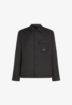 Melnā krekla ar pogām izgatavots no vieglām auduma, kam ir krūšu kabata un logo uzšuvums. Taisna piegriezuma ar vienkāršu apkakli un garām piedurknēm.