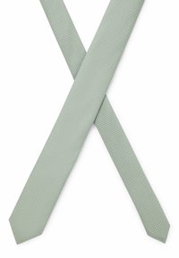 Cravate verte texturée avec un motif tissé, présentant un design slim et des extrémités pointues, disposée en position croisée.