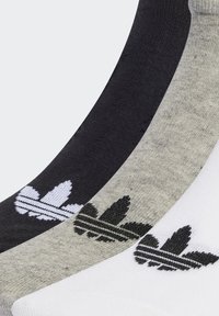Tre par sokker i sort, grå og hvid. Hver enkelt har Adidas trefoil-logoet med sorte og hvide striber. Blanding af bomuldsstof.