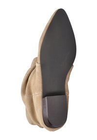 Botte chelsea en suède beige avec un design doux et froncé, bout pointu et un petit talon en bois. Semelle en caoutchouc noire avec texture rainurée. Taille 38.