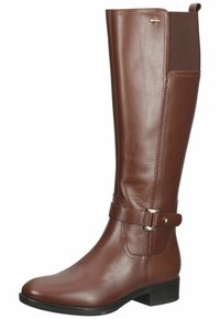 Bottes en cuir marron à hauteur de genou avec une finition lisse, talon plat, panneau élastique sur le côté et sangle décorative avec accents en métal argenté.