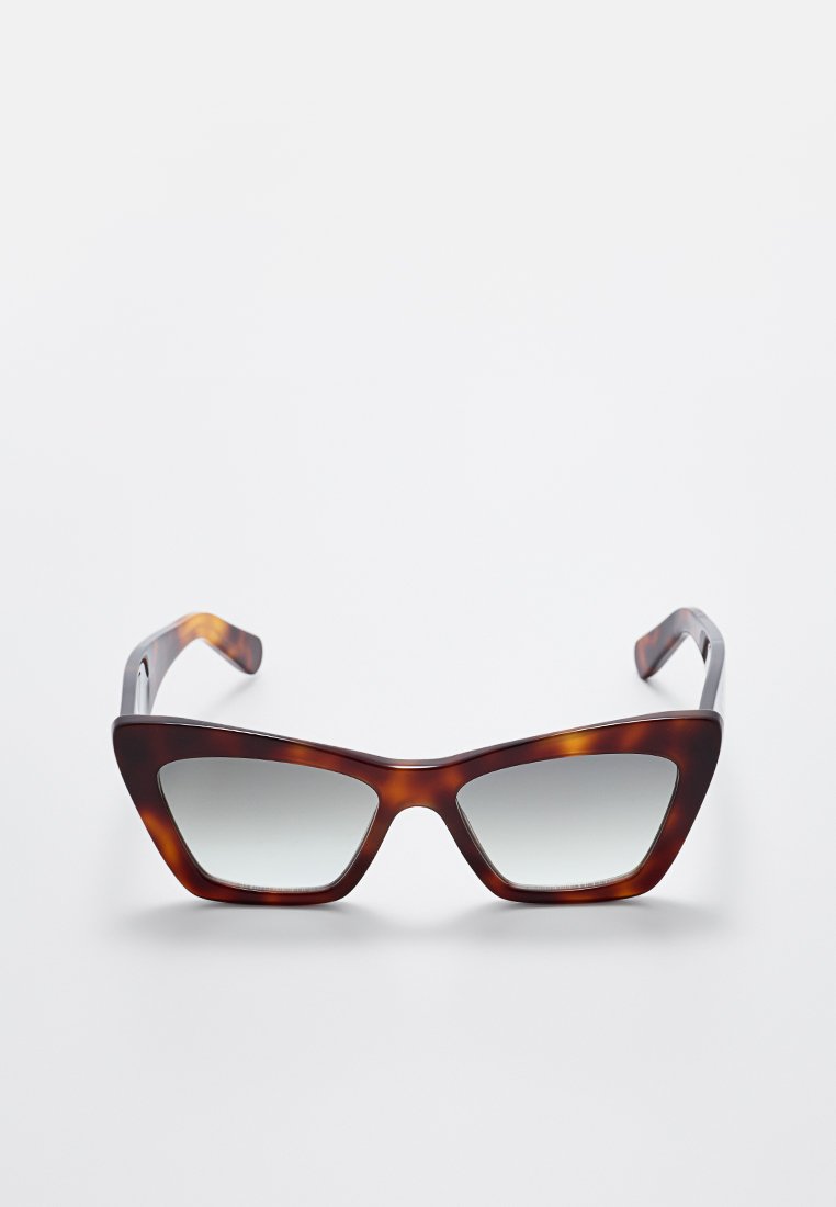 Gafas de sol de forma ojos de gato en carey con lentes grises degradados, exhibidas sobre un fondo blanco.