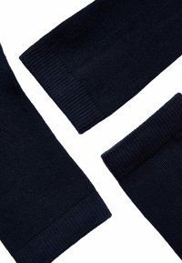 Detalles de tejido de punto azul marino, que incluyen puños acanalados y una textura suave, con tres secciones superpuestas.