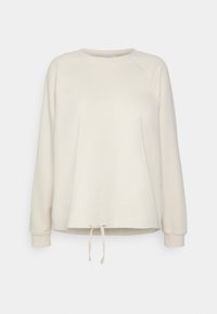 Krémová mikina vyrobená z měkkého materiálu, s kulatým výstřihem, dlouhými raglánovými rukávy a šňůrkovým lemem.