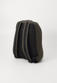 Zaino verde scuro con schienale imbottito in rete e spallacci larghi e regolabili; presenta una superficie liscia e resistente e un design minimalista.