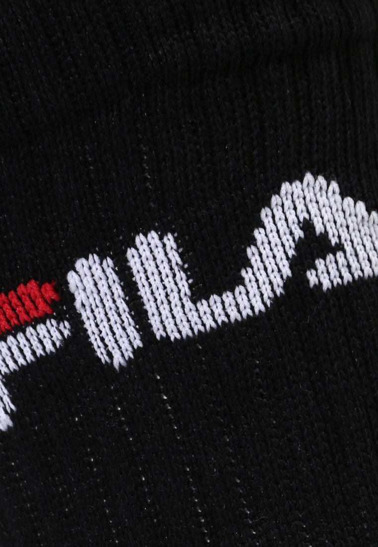 Calzino nero con texture a coste, caratterizzato dal logo "Fila" ricamato in bianco e rosso. Il design enfatizza un'estetica sportiva.