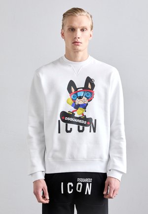Felpa bianca con una grafica colorata di un cane dei cartoni animati su una tavola da snowboard e il testo "ICON" sotto. Pantaloni neri con stampa "ICON" coordinata.