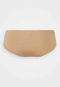 Beige brief with a seamless design, made of soft, stretchy material. Features a subtle logo at the waistband and smooth texture.
