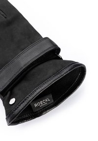 Gant en cuir noir à texture douce, doté d'un large poignet et d'un bouton pression argenté. L'étiquette intérieure indique "ROECKL MÜNCHEN."