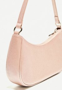Lyserød stof skuldertaske med en blank overflade, buet form, slank strop og subtil syningsdetalje, som har en lynlås lukning og metalbeslag.