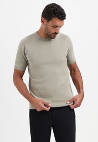 Korte mouw, ribgebreide t-shirt in lichtgroen. Heeft een ronde hals en een getailleerde pasvorm met een subtiele textuur.