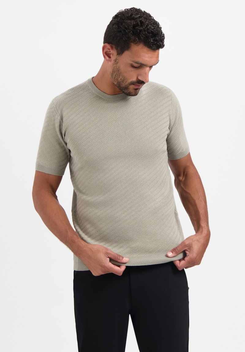 Korte mouw, ribgebreide t-shirt in lichtgroen. Heeft een ronde hals en een getailleerde pasvorm met een subtiele textuur.