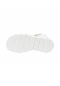 Sandalia blanca con suela de goma texturizada que presenta ranuras horizontales, correas suaves y un diseño minimalista para una comodidad transpirable.