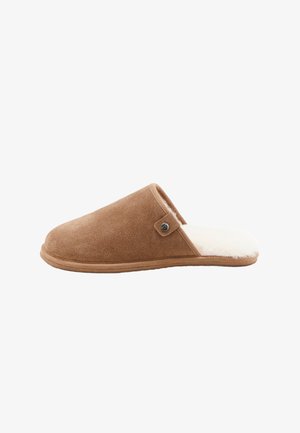 Chausson en suede marron avec une douce doublure en fourrure blanche, bout arrondi, talon fermé et un détail de bouton décoratif sur le côté.