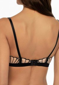 Czarny i cielisty biustonosz z koronkowym wykończeniem i regulowanymi ramiączkami, z zapięciem na haftkę z tyłu oraz gładkim, teksturowanym wykończeniem.