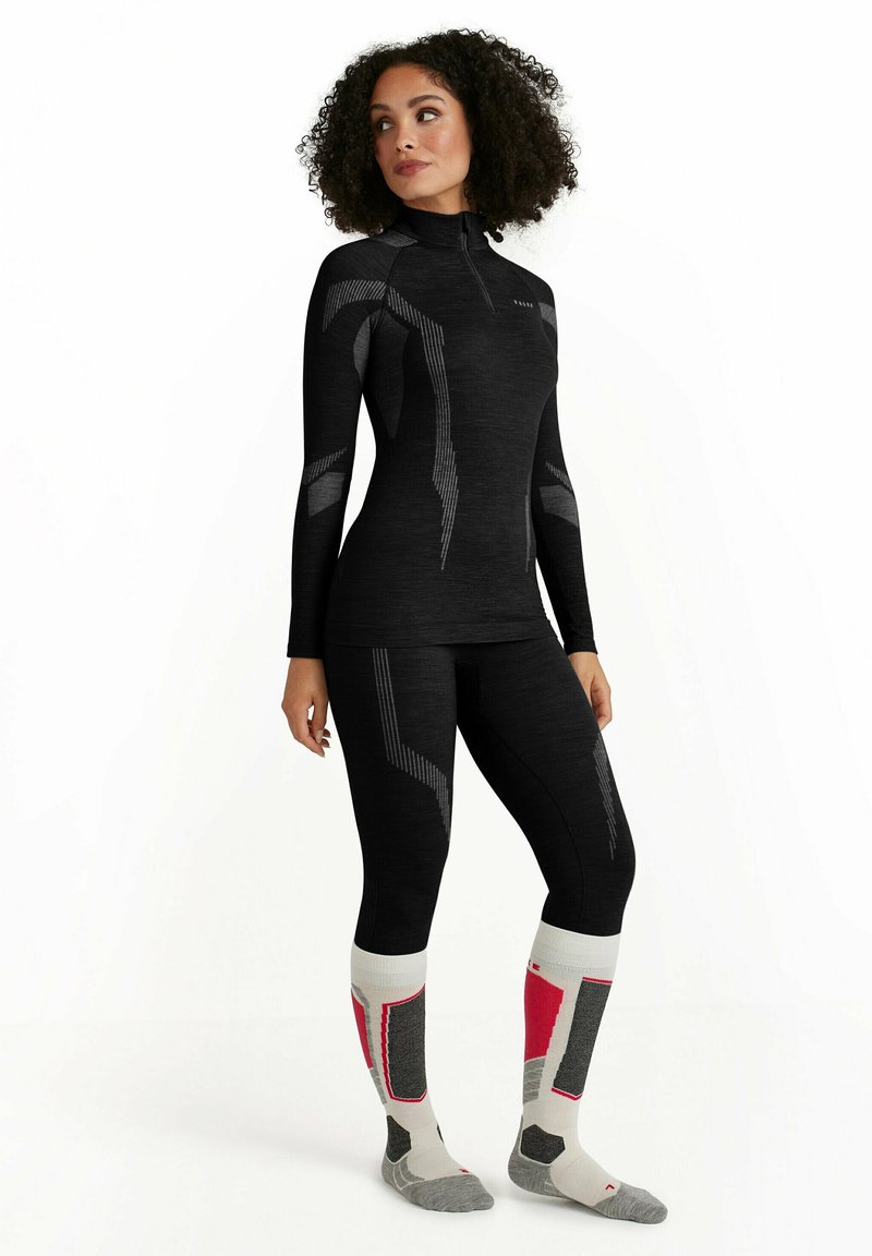 Ensemble de couche de base thermique noire avec un col montant, présentant des accents et des motifs gris. Comprend des chaussettes montantes avec des détails rouges et gris.