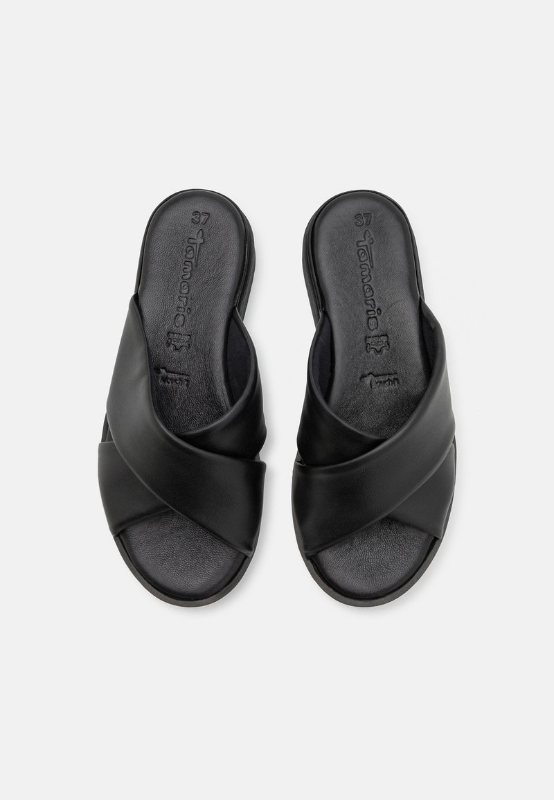 Sandales noires à brides croisées, fabriquées en matériau simili cuir lisse. Semelle intérieure ergonomique et semelle extérieure texturée pour plus de confort. Taille 37.