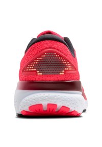Zapatilla deportiva roja con parte superior de malla, cuello acolchado y suela de goma. Presenta un diseño de tacón triangular con un patrón texturizado y una media suela blanca.