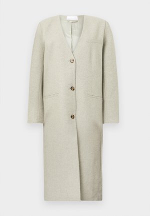 Lys grå lang kåpe med v-hals, tre knapper, to sidelommer og strukturerte skuldre. Laget av et mykt, teksturert stoff.