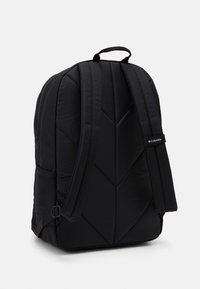 Černý polstrovaný batoh s geometrickým prošívaným vzorem, nastavitelnými popruhy a horním držadlem. Logo značky zobrazené na boku.