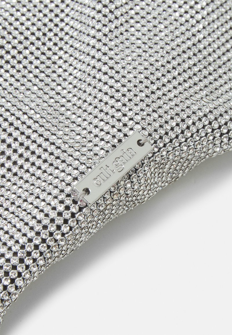 Tissu en maille argenté avec une surface texturée recouverte de petites clous brillants. Comprend une étiquette en métal avec l'inscription "cult gin."
