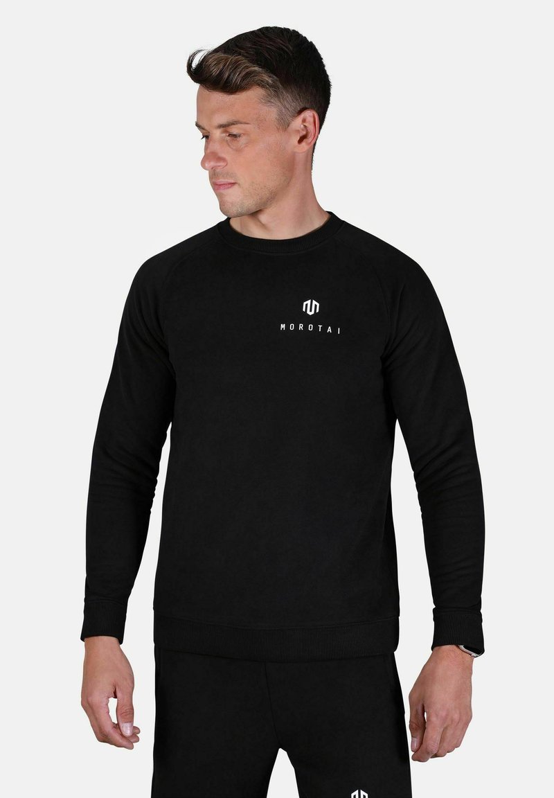 Sudadera negra con cuello y puños de canalé. Presenta el logo blanco "Morotai" en el pecho. Tejido suave, diseño ajustado.