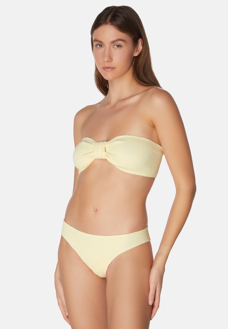 Gult bikini-set tillverkat av texturerat tyg, med en strapless-top som har en rosettdetalj och matchande lågt skurna underdelar.
