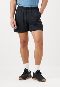 Svart idrettsshorts med elastisk midje og snor, med sidelommer og en glatt, lett stoffstruktur.