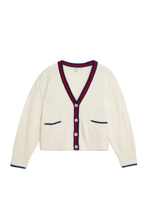 Strickjacke in Creme mit V-Ausschnitt, kontrastierenden navyblauen und roten Akzenten, zwei Fronttaschen und Knopfverschluss. Strukturierte Rippenbündchen und Saum.