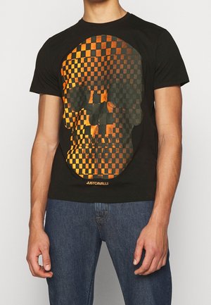 Zwarte katoenen t-shirt met een groot oranje en zwart geruit schedelontwerp. Korte mouwen en ronde halslijn, met subtiele branding aan de onderkant.