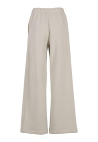 Pantalons larges beiges avec une taille élastique, fabriqués dans un matériau doux. Dotés de poches latérales et d'une texture lisse.