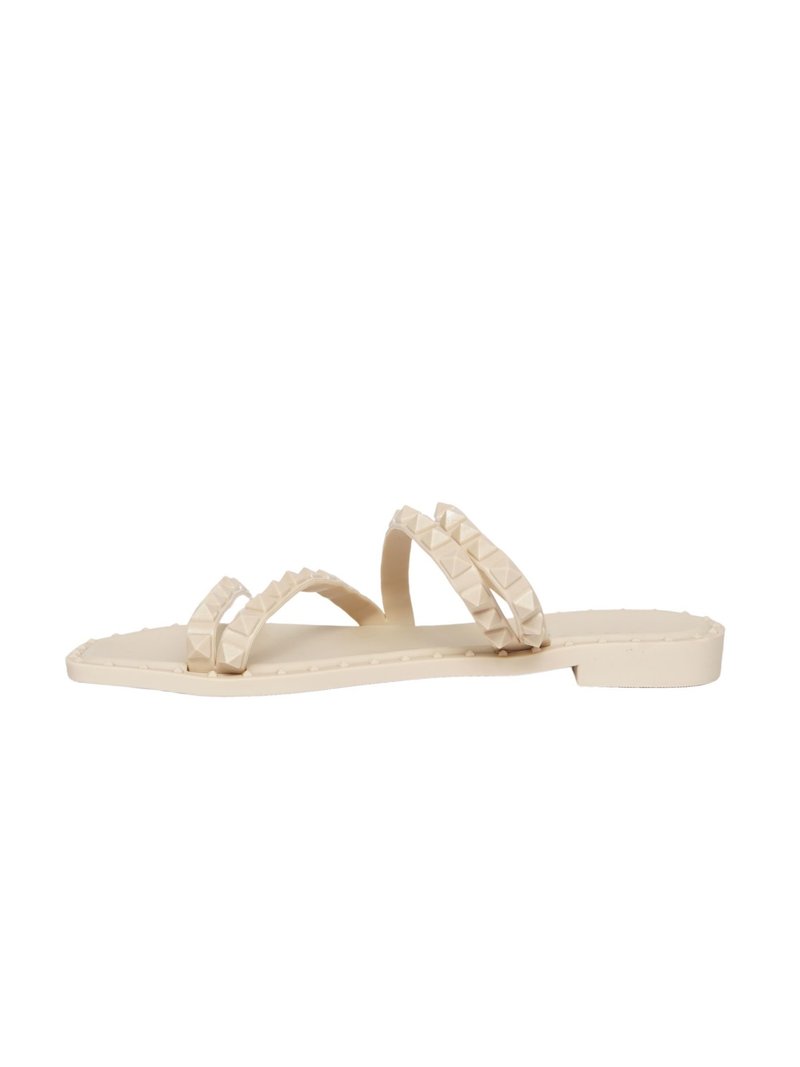 Sandali modellati beige con due cinturini testurizzati e dettagli a piramide, suola piatta e design minimalista. Adatti per un abbigliamento casual.