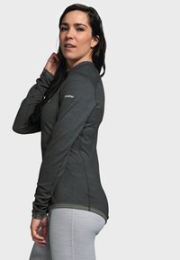 Langärmliges, enganliegendes Sportoberteil in Dunkelgrau, aus strukturiertem Material, mit rundem Ausschnitt und dezentem Branding auf der Schulter.