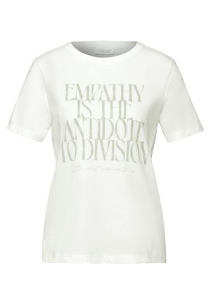 Camiseta de algodón blanca con un gran texto gris que dice "LA EMPATÍA ES EL ANTÍDOTO A LA DIVISIÓN" y texto adicional pequeño debajo.