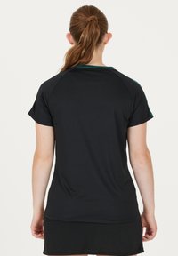 Sort atletisk t-shirt med korte ærmer, glat tekstur og grønne detaljer ved kraven og skuldrene, med en afslappet pasform.