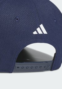 Donkerblauwe honkbalpet gemaakt van gestructureerde stof met een verstelbare plastic band. Voorzien van een wit Adidas-logo en werkende ventilatiegaatjes.