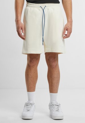 Light cream shorts with an elastic waistband and blue drawstring, featuring a smooth texture and subtle branding near the hem.
