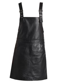 Zwarte leren schort jurk met verstelbare gespspannen, zijknopen, zakken en een gladde textuur. Kenmerkt een getailleerde taille en een uitlopende zoom.