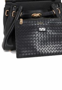 Black leather handbag with a woven texture on a detachable pouch. Features gold hardware and a secure zip closure, with a stylish silhouette.