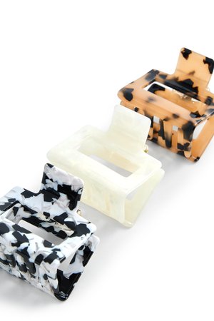 Tres horquillas rectangulares con diseño en colores negro y blanco, crema translúcido y marrón carey sobre un fondo blanco.