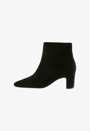 Schwarze Wildleder-Stiefelette mit spitzem Zehenbereich, glatter Oberfläche und mittlerem, quadratischem Absatz. Schlichtes Design ohne sichtbare Verzierungen.