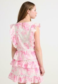 Różowa sukienka w stylu tie-dye z falbaniastymi rękawami i warstwową spódnicą. Posiada koronkowe detale oraz małe zapięcie na guzik z tyłu.
