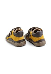 Zapatos para niño pequeños de ante y cuero en tonos marrón y amarillo con suela de goma, tiras de velcro y costuras contrastantes en un diseño redondeado y resistente.