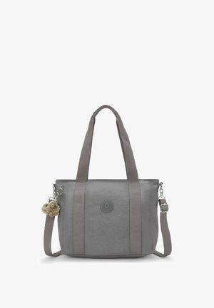 Bolsa de tela gris con doble asa superior, correa ajustable para el hombro y un llavero peludo como detalle. Presenta un logotipo prominente en la parte delantera.