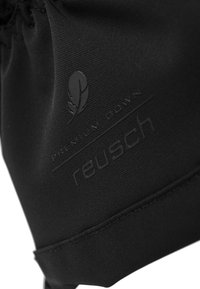 Schwarzer Stoff mit glatter Textur, der das geprägte Branding "reusch" und "Premium Down" sowie ein Blattlogo zeigt. Keine weiteren Details sichtbar.
