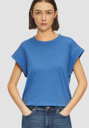 Blauwe T-shirt met korte mouwen en een ronde halslijn, gemaakt van zachte katoen. Heeft een losse pasvorm en opgerolde mouwen. Gekocht met donkere spijkerbroeken.