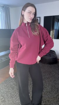 Tamsiai raudona. Užtraukiama sportinė palaidinė su aukštu apykakliu ir ilgomis rankovėmis, derinama su juodomis platėjančiomis kelnėmis. Lygi audinio tekstūra; paprastas dizainas.